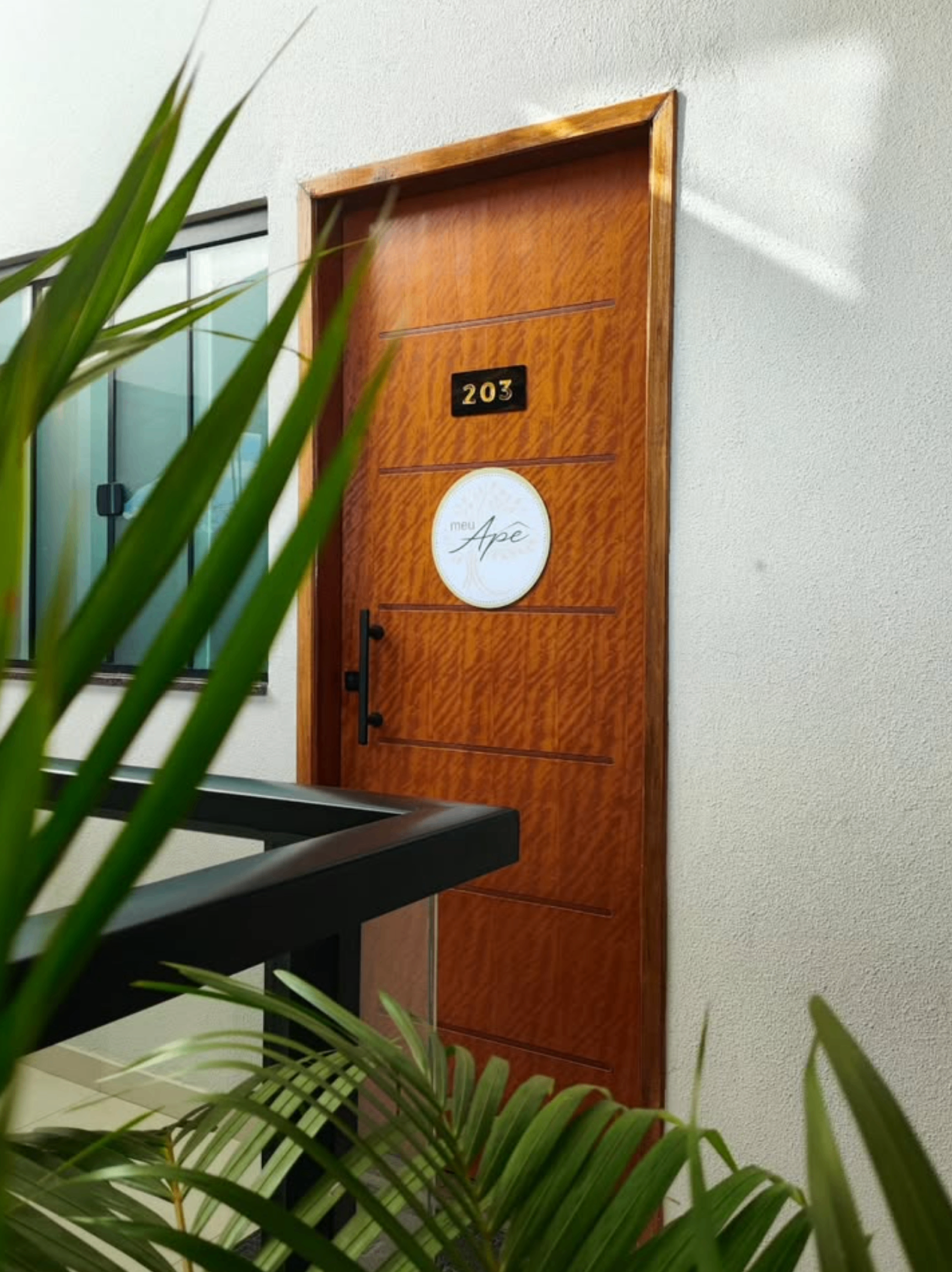 Porta do Meu Apê com placa e número 203 em Carvalhos